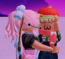 A screenshot of Mirai and Very Berry Fast from Tower Heroes. Mirai is hugging and kissing Berry on the cheek while Berry holds the brim of her hat and holds Mirai.